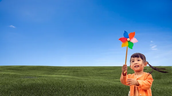 Closeup of little girl blowing wind wheel — Stock Photo, Image