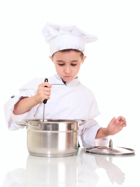 小男孩厨师用勺子搅拌锅 — 图库照片