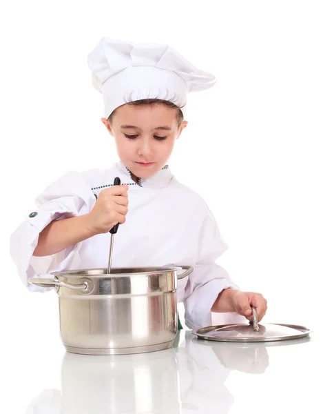 Kleine jongen chef-kok met pollepel stiring in de pot — Stockfoto