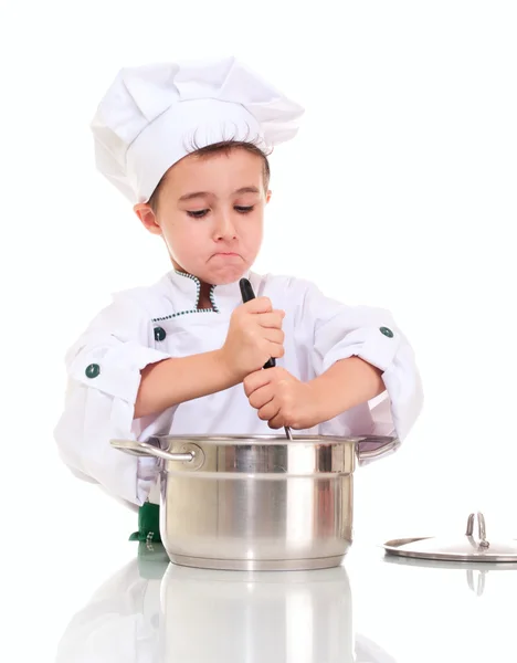 Petit garçon chef avec louche en remuant dans le pot par les deux mains — Photo