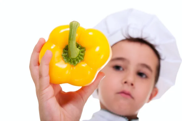 Häuptling kleiner Junge hält saftigen gelben Paprika in der Hand Stockbild