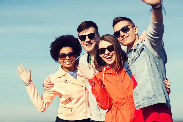 Amigos adolescentes felices en tonos agitando las manos — Foto de Stock