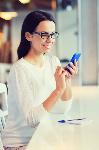 Mulher sorridente com smartphone no café — Fotografia de Stock