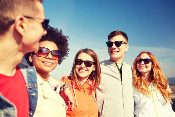 Happy dospívající přátelé v odstínech mluví na ulici — Stock fotografie
