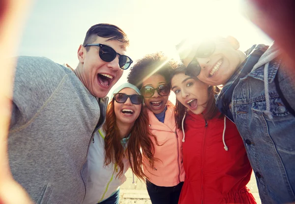 happy laughing friends taking selfie