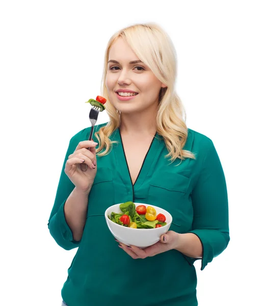 Sorrindo jovem mulher comendo salada de legumes — Fotografia de Stock