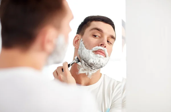 Homme rasage barbe avec lame de rasoir à la salle de bain — Photo