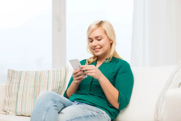 Mulher feliz com smartphone em casa — Fotografia de Stock