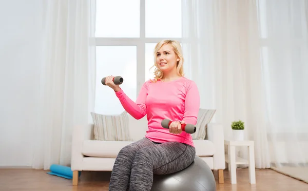 Lächelnde Frau mit Hanteln beim Training zu Hause — Stockfoto