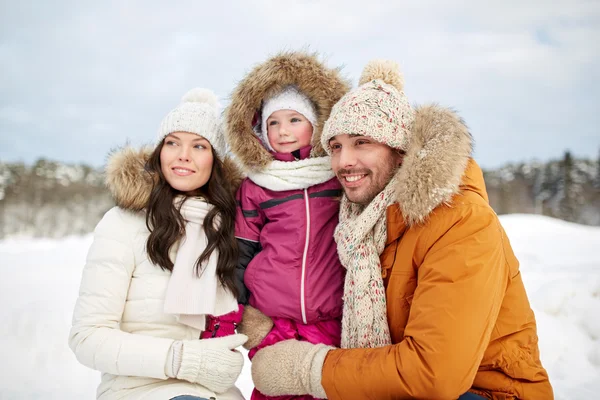 Gelukkig gezin met kind in winterkleren buitenshuis — Stockfoto