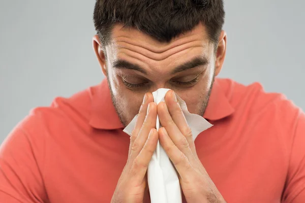 Malade homme soufflant nez à serviette en papier à la maison — Photo