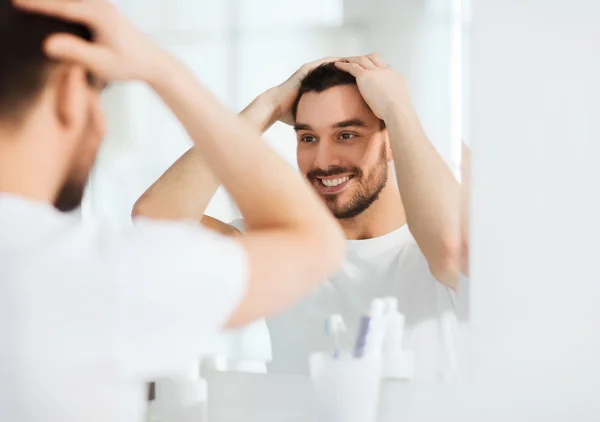 Jovem feliz olhando para o espelho, em casa, casa de banho — Fotografia de Stock