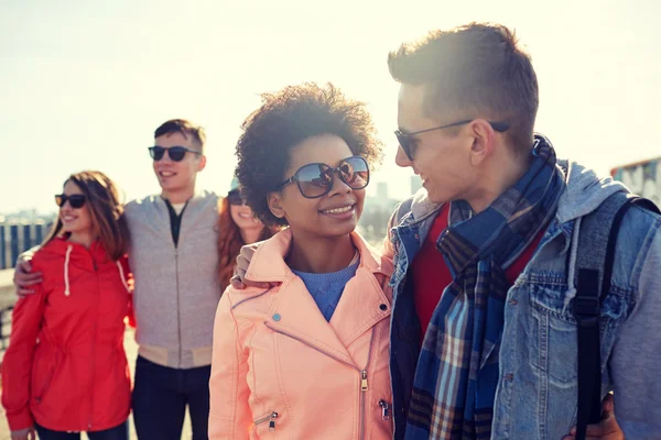 Happy teenage friends in shades talking on street — Stock Photo, Image