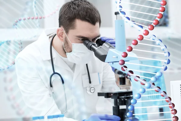 Jovem cientista olhando para microscópio em laboratório — Fotografia de Stock