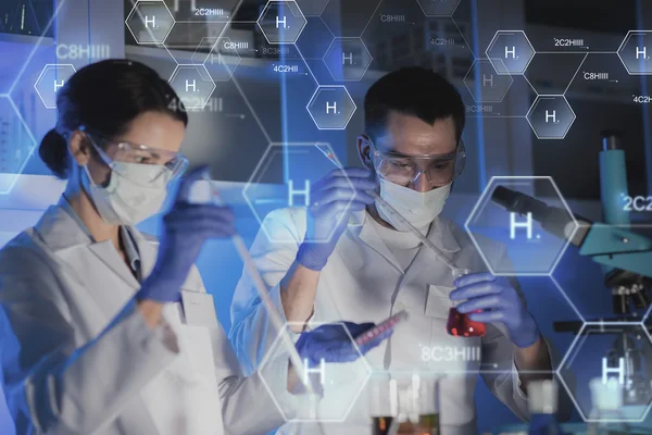 Perto de cientistas que fazem testes em laboratório — Fotografia de Stock