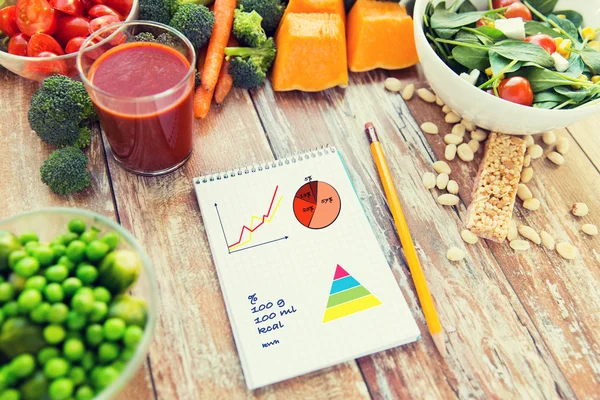 Close up of ripe vegetables and notebook on table — Stock Photo, Image