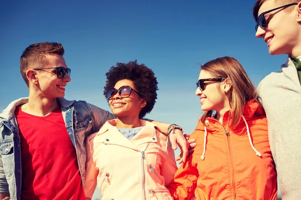 Happy dospívající přátelé v odstínech mluví na ulici — Stock fotografie
