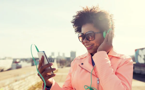 Jeune femme heureuse avec smartphone et écouteurs — Photo