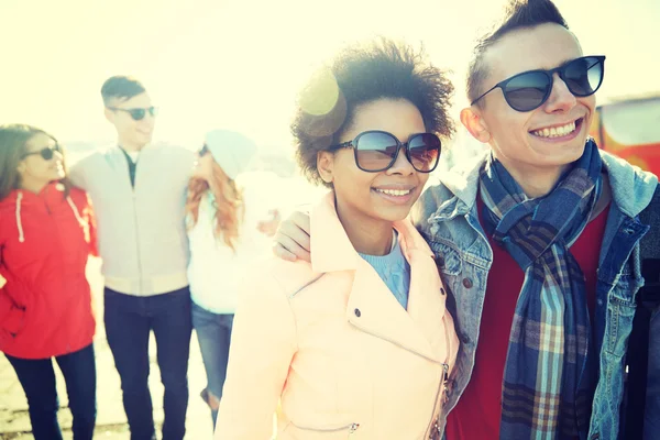 Happy teenage friends in shades hugging on street — Stock Photo, Image