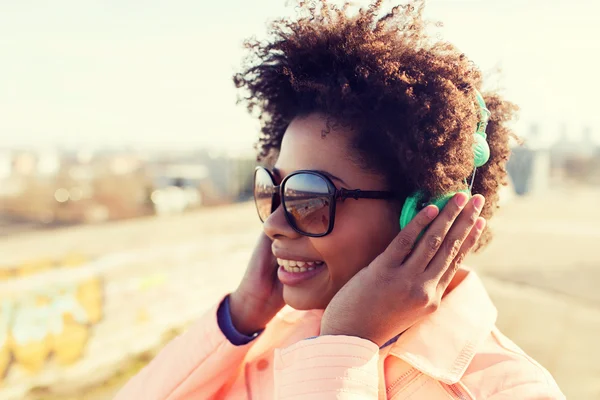 Felice giovane donna in cuffia ascoltare musica — Foto Stock