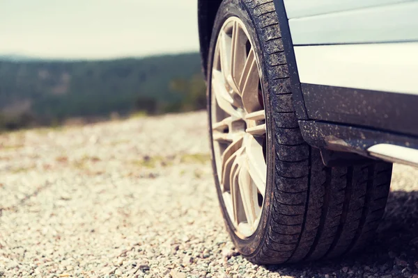 Close up of dirty car wheel on cliff — Stock Photo, Image