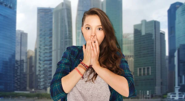 Scared teenage girl over singapore city background — Stockfoto