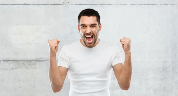 Joven celebrando la victoria sobre gris —  Fotos de Stock