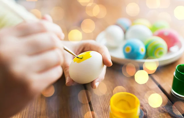 Primer plano de las manos de la mujer para colorear huevos de Pascua — Foto de Stock