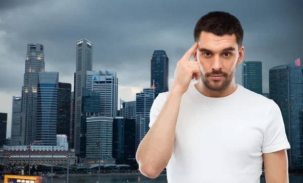 Hombre con el dedo en el templo sobre la ciudad de Singapur — Foto de Stock