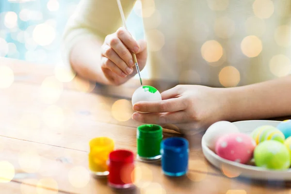 Close up of woman hands coloring easter eggs — Stock Photo, Image