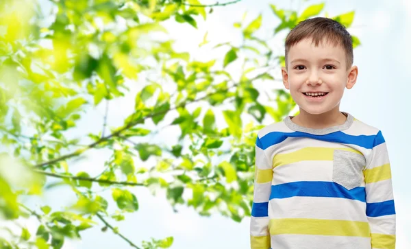 緑の自然な背景の上に微笑む小さな男の子 — ストック写真