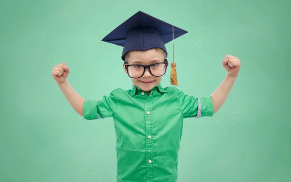 Happy boy v bakalářské klobouk znázorňující výkon — Stock fotografie