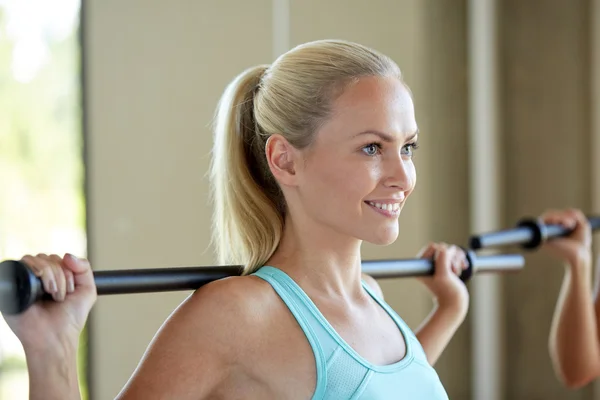 Glückliche Frau trainiert mit Bar im Fitnessstudio — Stockfoto