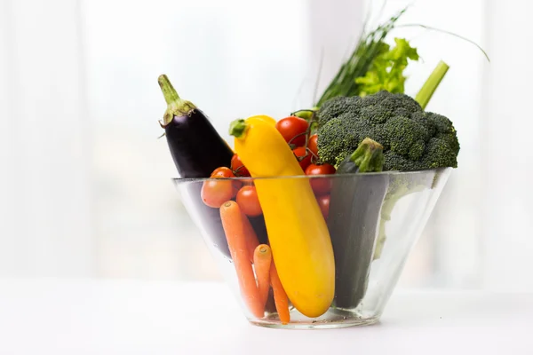 Närbild på mogen grönsaker i glasskål på bord — Stockfoto