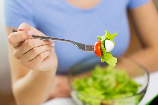 Close up of young woman eating salad at home — Stock Photo, Image