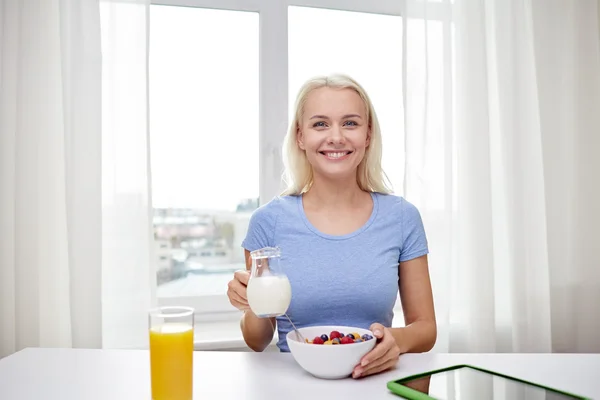 Mujer con leche y copos de maíz desayunando —  Fotos de Stock