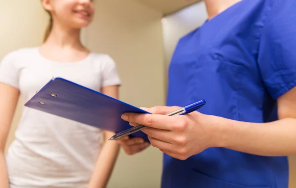 Close up of nurse with clipboard and pen with girl — Stock fotografie