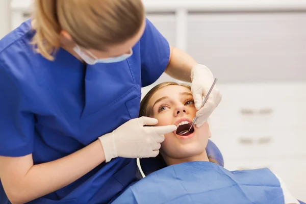 Dentista femenino chequeando dientes de niña paciente — Foto de Stock