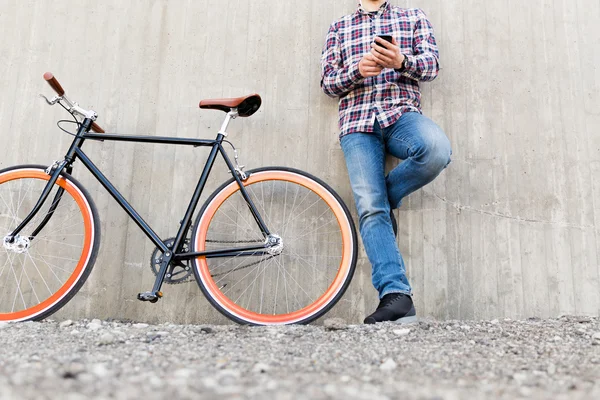 スマート フォンと自転車の流行に敏感な男のクローズ アップ — ストック写真