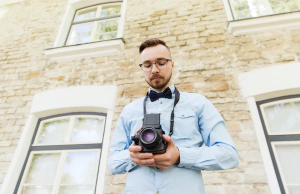 Feliz jovem hipster homem com câmera de filme na cidade — Fotografia de Stock