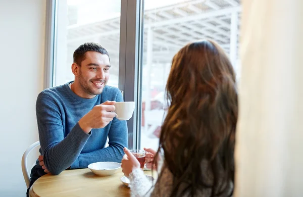 Happy couple drinking tea and coffee at cafe — Stock Photo, Image