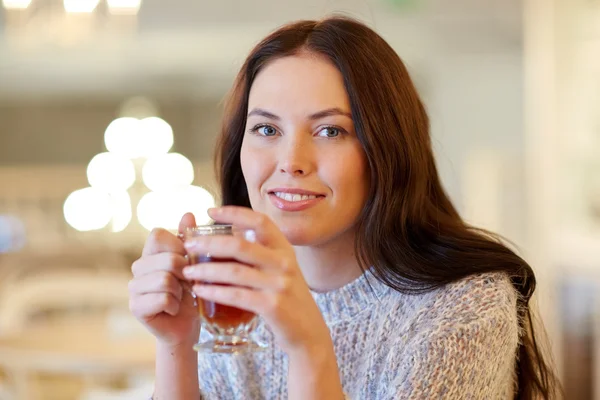 Χαμογελώντας νεαρή γυναίκα πίνοντας τσάι στο café — Φωτογραφία Αρχείου