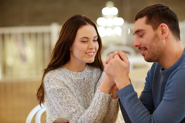 Счастливая пара, держащаяся за руки в ресторане или кафе — стоковое фото