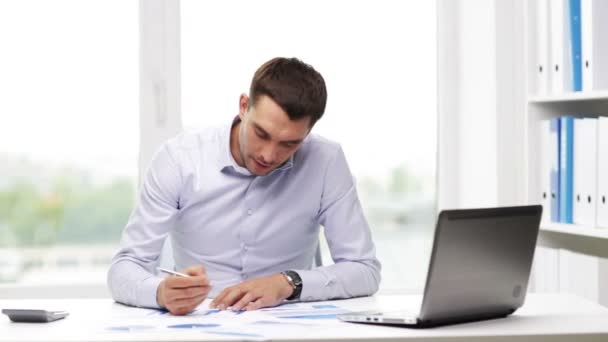 Ocupado homem de negócios com laptop e papéis no escritório — Vídeo de Stock