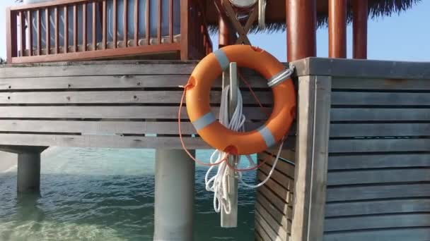 Patio de playa o terraza con boya salvavidas en agua de mar — Vídeo de stock