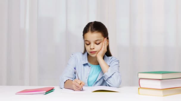 Chica de la escuela aburrida con libros y bloc de notas en casa — Vídeo de stock