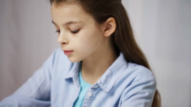 Chica de la escuela aburrida con libros y bloc de notas en casa — Vídeo de stock