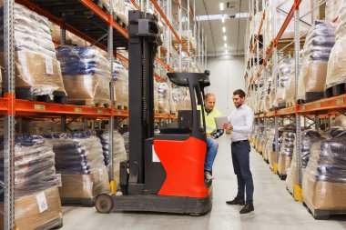 men with tablet pc and forklift at warehouse clipart