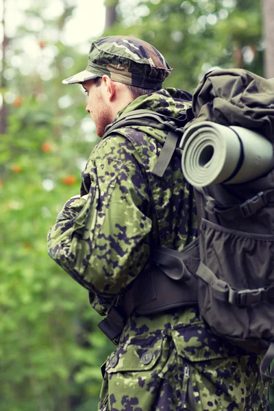 Ung soldat med ryggsäck i skogen — Stockfoto