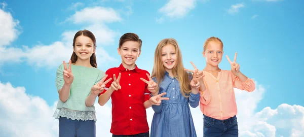 Niño feliz y las niñas mostrando la paz signo de mano —  Fotos de Stock